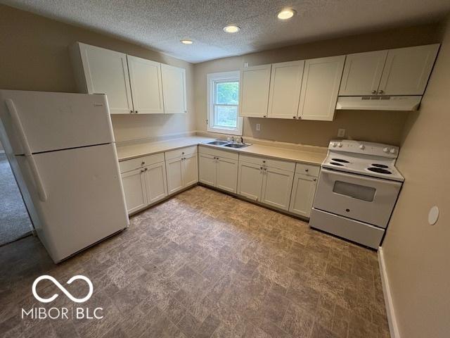 2413 N Macedonia Ave, Muncie, IN 47303 - kitchen featuring white appliances, under cabinet range hood, a textured ceiling, white cabinetry, and light countertops