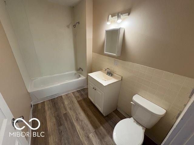2413 N Macedonia Ave, Muncie, IN 47303 - full bathroom featuring vanity, wood finished floors,  shower combination, and tile walls