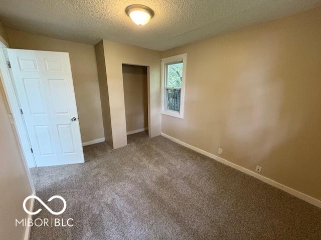 2413 N Macedonia Ave, Muncie, IN 47303 - unfurnished bedroom with a textured ceiling, carpet floors, and a closet