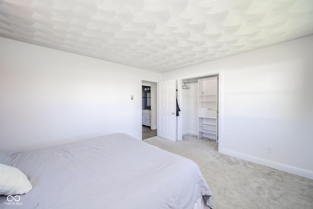 carpeted bedroom featuring baseboards and a closet