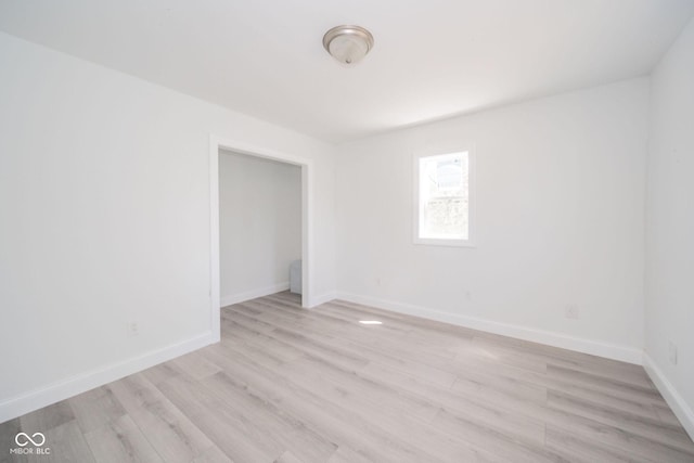 empty room with baseboards and light wood-type flooring