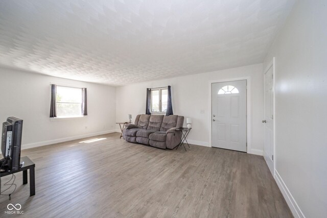 unfurnished living room with baseboards and wood finished floors