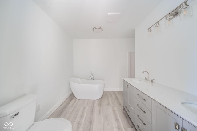 bathroom with a sink, a soaking tub, toilet, and wood finished floors