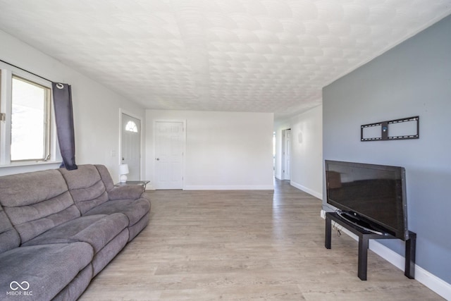 living area with baseboards and light wood-style flooring
