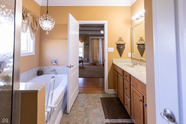 full bathroom featuring an inviting chandelier, a garden tub, vanity, and crown molding