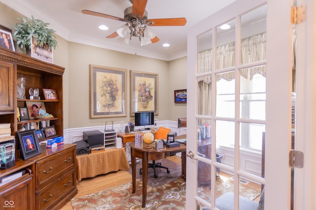 office with crown molding, light wood finished floors, ceiling fan, and wainscoting