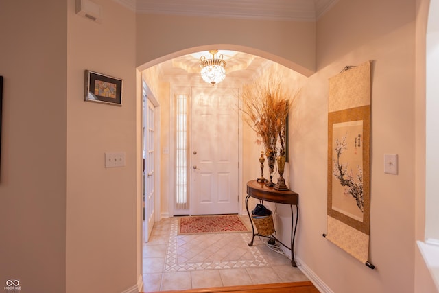 entryway with baseboards, arched walkways, light tile patterned flooring, and ornamental molding