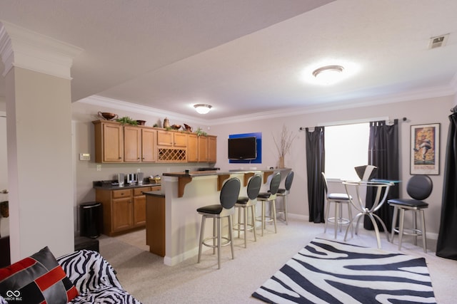 interior space with a kitchen bar, crown molding, and light carpet