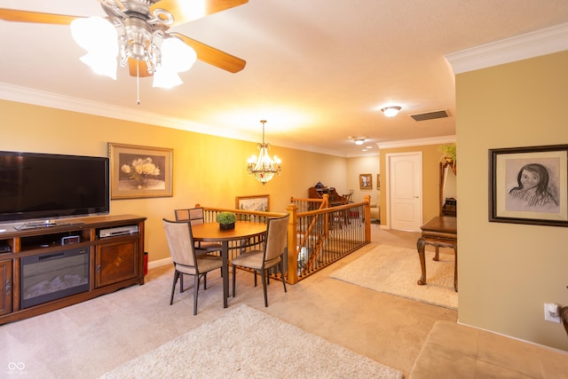 dining area featuring carpet, visible vents, crown molding, and ceiling fan with notable chandelier