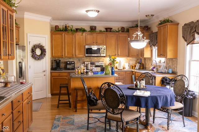 kitchen with appliances with stainless steel finishes, backsplash, a kitchen island, and a sink