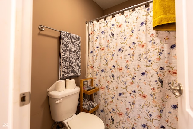 full bathroom with toilet and a shower with shower curtain