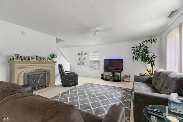 853 Westpointe Dr, Shelbyville, IN 46176 - living room featuring a textured ceiling, visible vents, a fireplace with raised hearth, ceiling fan, and carpet floors