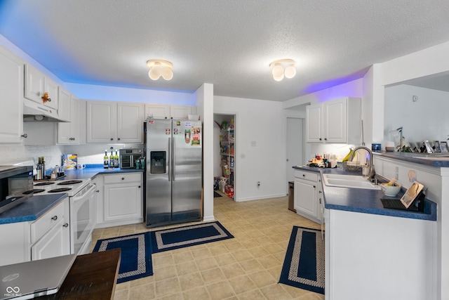853 Westpointe Dr, Shelbyville, IN 46176 - kitchen with dark countertops, a sink, stainless steel appliances, white cabinetry, and under cabinet range hood