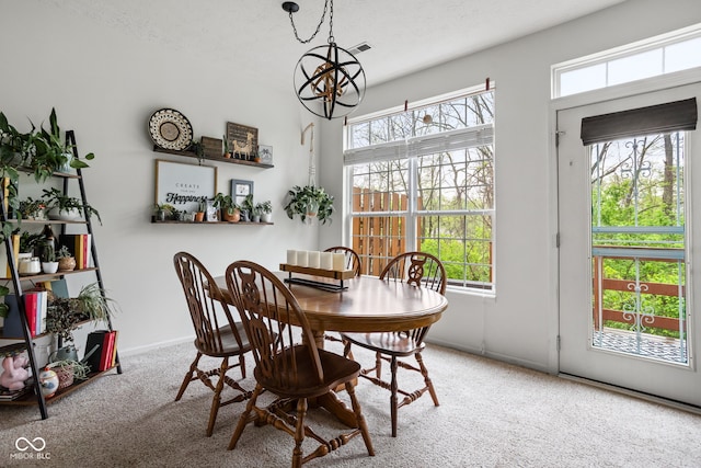 dining area with baseboards, carpet, and a notable chandelier