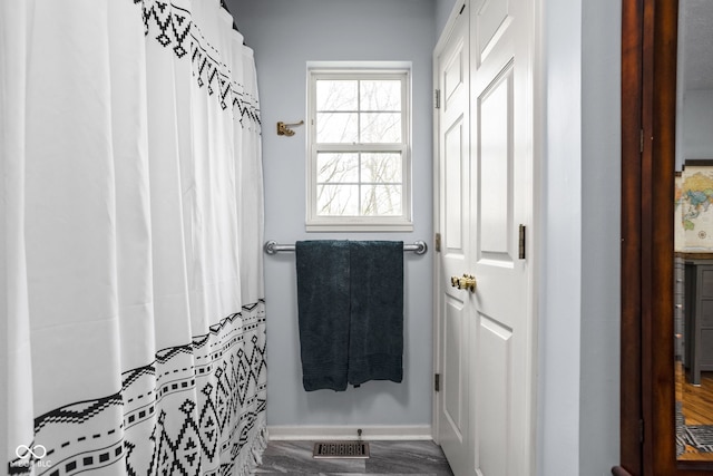 bathroom with baseboards, visible vents, and curtained shower