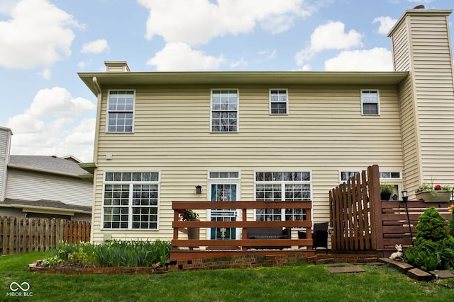 rear view of house with a deck and fence