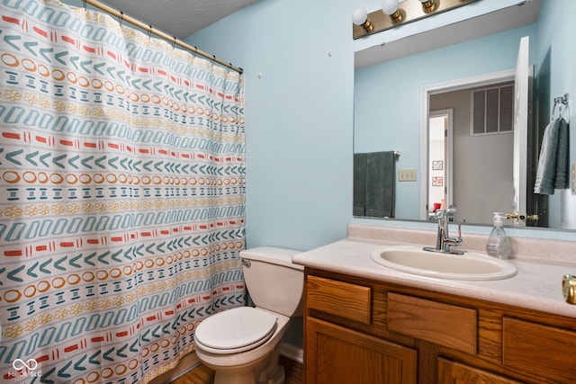 bathroom featuring vanity, toilet, and visible vents