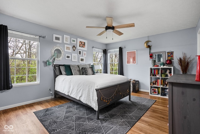 bedroom with baseboards, a ceiling fan, and wood finished floors