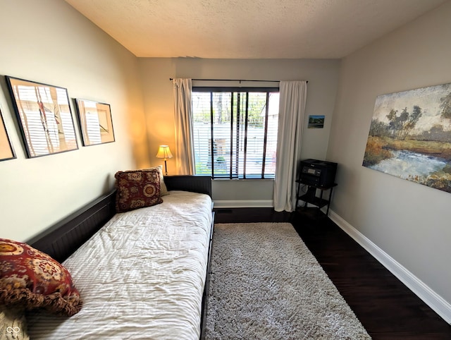 bedroom with baseboards and dark wood-style floors