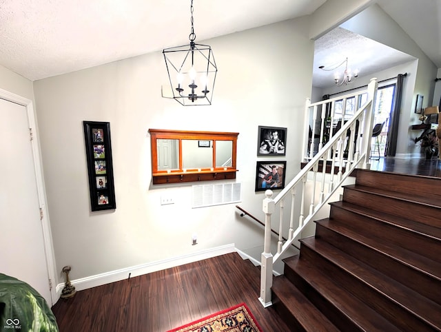 stairway with baseboards, wood finished floors, and a notable chandelier