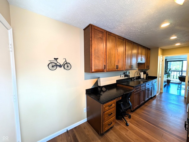 office area featuring baseboards, dark wood-type flooring, recessed lighting, a textured ceiling, and a sink