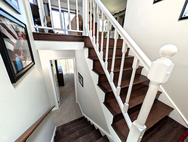 staircase with carpet floors and wood finished floors