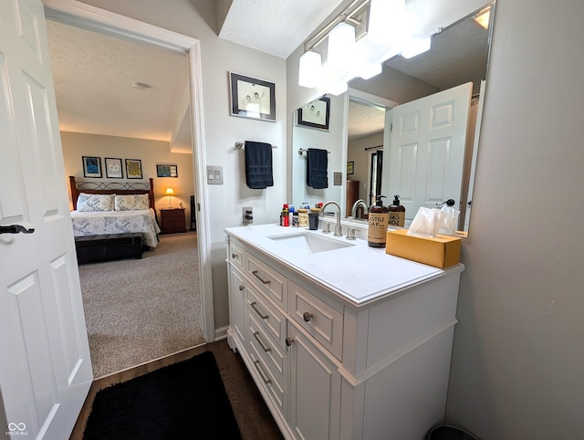 bathroom with vanity, connected bathroom, and a textured ceiling