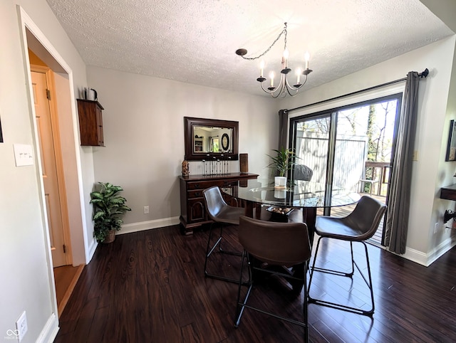 dining room with baseboards, a textured ceiling, dark wood-type flooring, and a chandelier