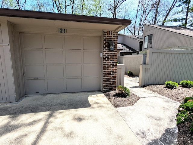 garage featuring fence and driveway