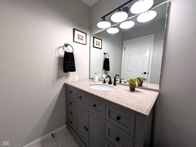 bathroom featuring baseboards, vanity, and marble finish floor