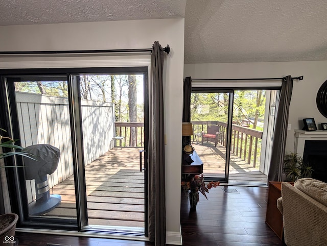 doorway to outside with a textured ceiling and dark wood-style floors