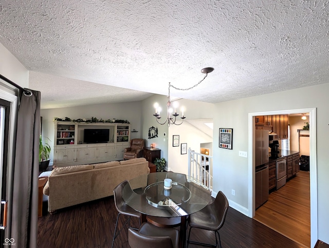 dining room with dark wood-style flooring, a textured ceiling, a chandelier, and baseboards