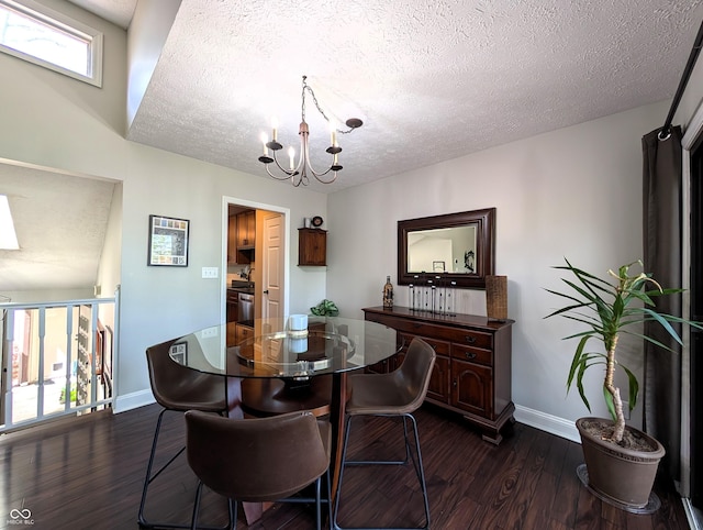 dining room with dark wood-type flooring, a textured ceiling, baseboards, and a chandelier