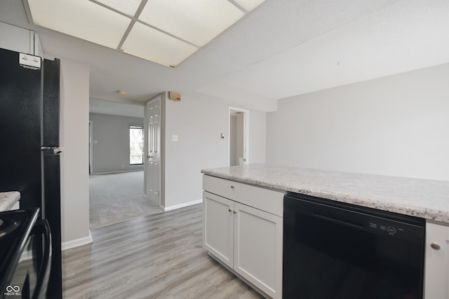 kitchen with light wood-style floors, baseboards, black dishwasher, range, and white cabinetry