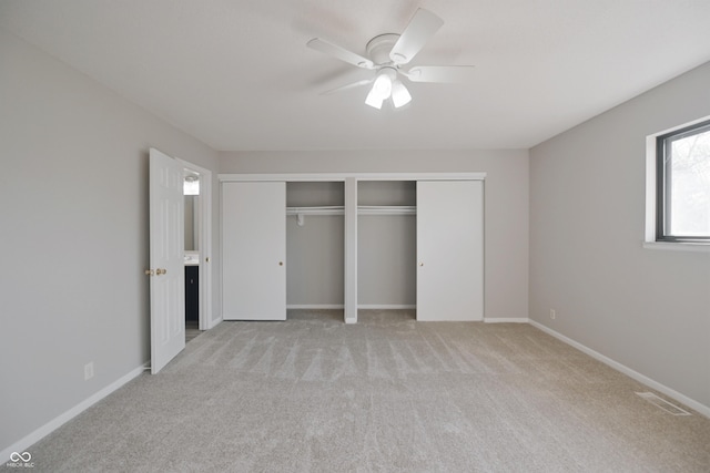 unfurnished bedroom with baseboards, visible vents, a ceiling fan, and light colored carpet