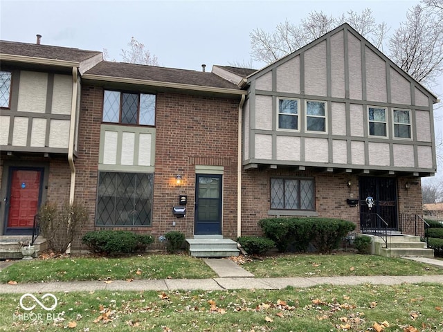 view of front of property featuring entry steps, brick siding, and stucco siding