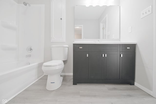 bathroom featuring wood finished floors, baseboards, vanity, and toilet