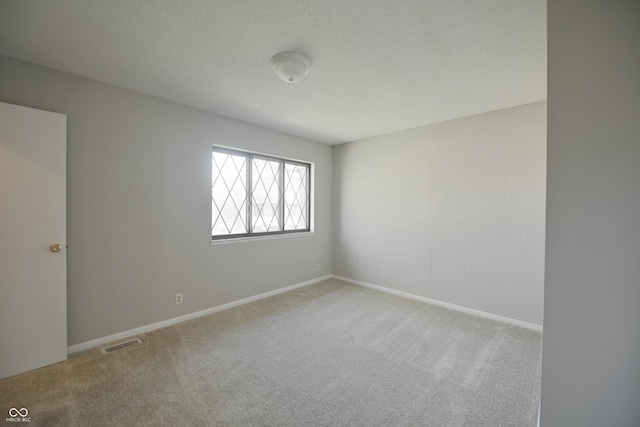 carpeted empty room featuring visible vents and baseboards