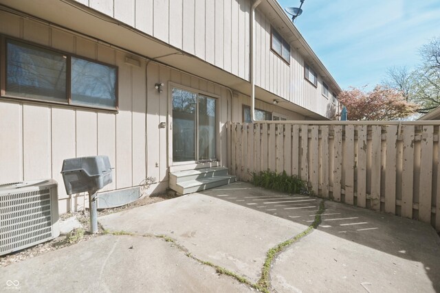 view of patio / terrace featuring fence, entry steps, and central air condition unit