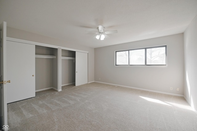 unfurnished bedroom with ceiling fan, baseboards, a closet, and light colored carpet