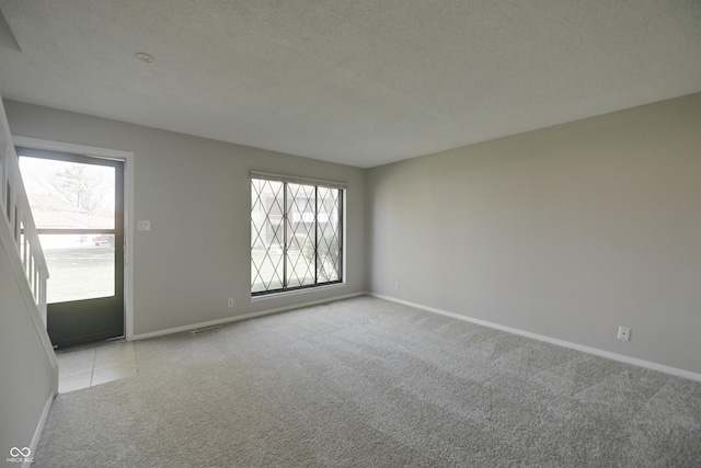 carpeted spare room featuring a wealth of natural light and baseboards