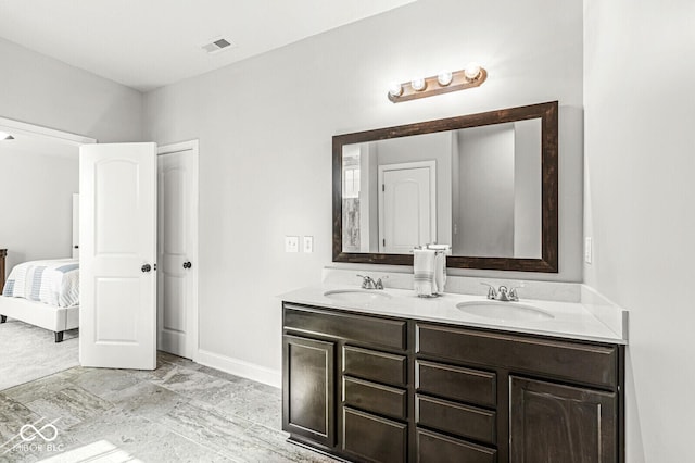 full bathroom featuring connected bathroom, double vanity, visible vents, and a sink