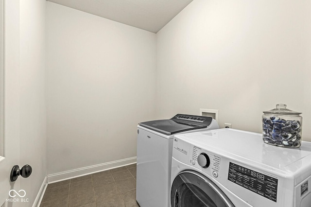 washroom featuring washer and dryer, laundry area, and baseboards