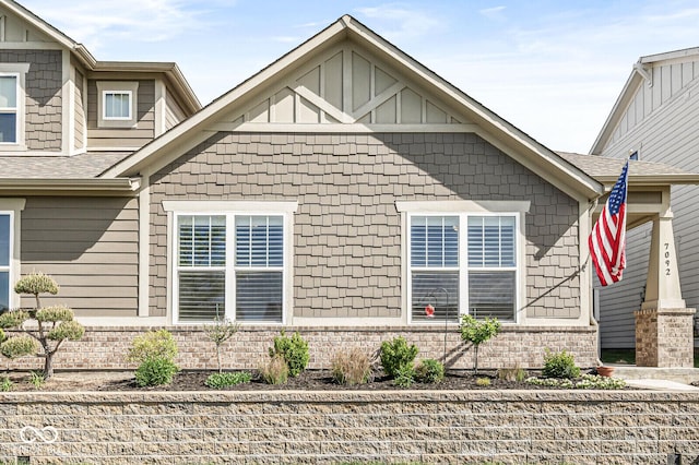 view of home's exterior with board and batten siding and roof with shingles