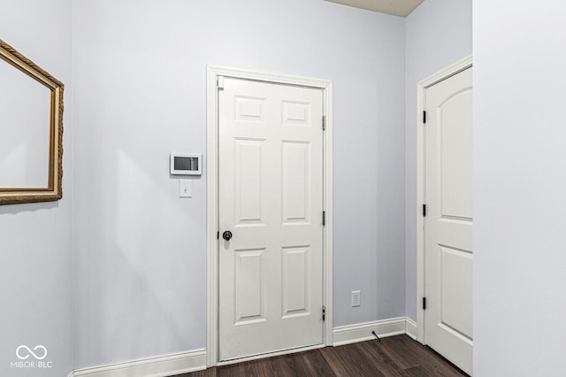 interior space with baseboards and dark wood-style flooring