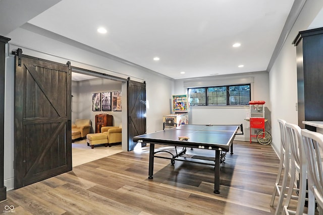 10725 Holliday Farms Blvd, Zionsville, IN 46077 - rec room with a barn door, light wood finished floors, recessed lighting, crown molding, and baseboards