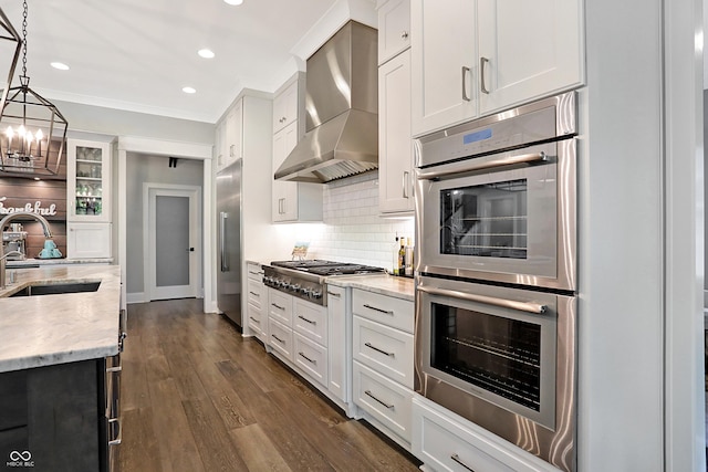 10725 Holliday Farms Blvd, Zionsville, IN 46077 - kitchen featuring a sink, appliances with stainless steel finishes, wall chimney range hood, tasteful backsplash, and a chandelier