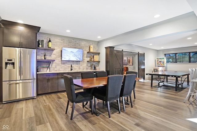 10725 Holliday Farms Blvd, Zionsville, IN 46077 - dining area featuring a barn door, light wood-style flooring, and recessed lighting