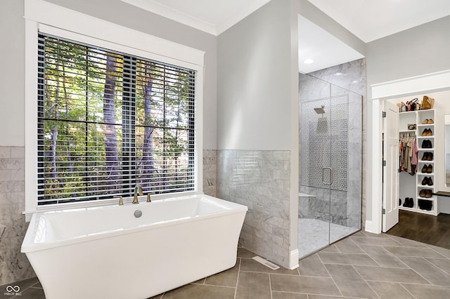 10725 Holliday Farms Blvd, Zionsville, IN 46077 - full bath featuring tile walls, a spacious closet, a shower stall, a freestanding bath, and tile patterned flooring