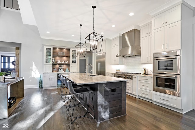 10725 Holliday Farms Blvd, Zionsville, IN 46077 - kitchen featuring wall chimney exhaust hood, stainless steel appliances, dark wood finished floors, decorative backsplash, and white cabinets